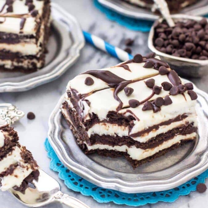 Slice of chocolate icebox cake on a plate with one bite missing.