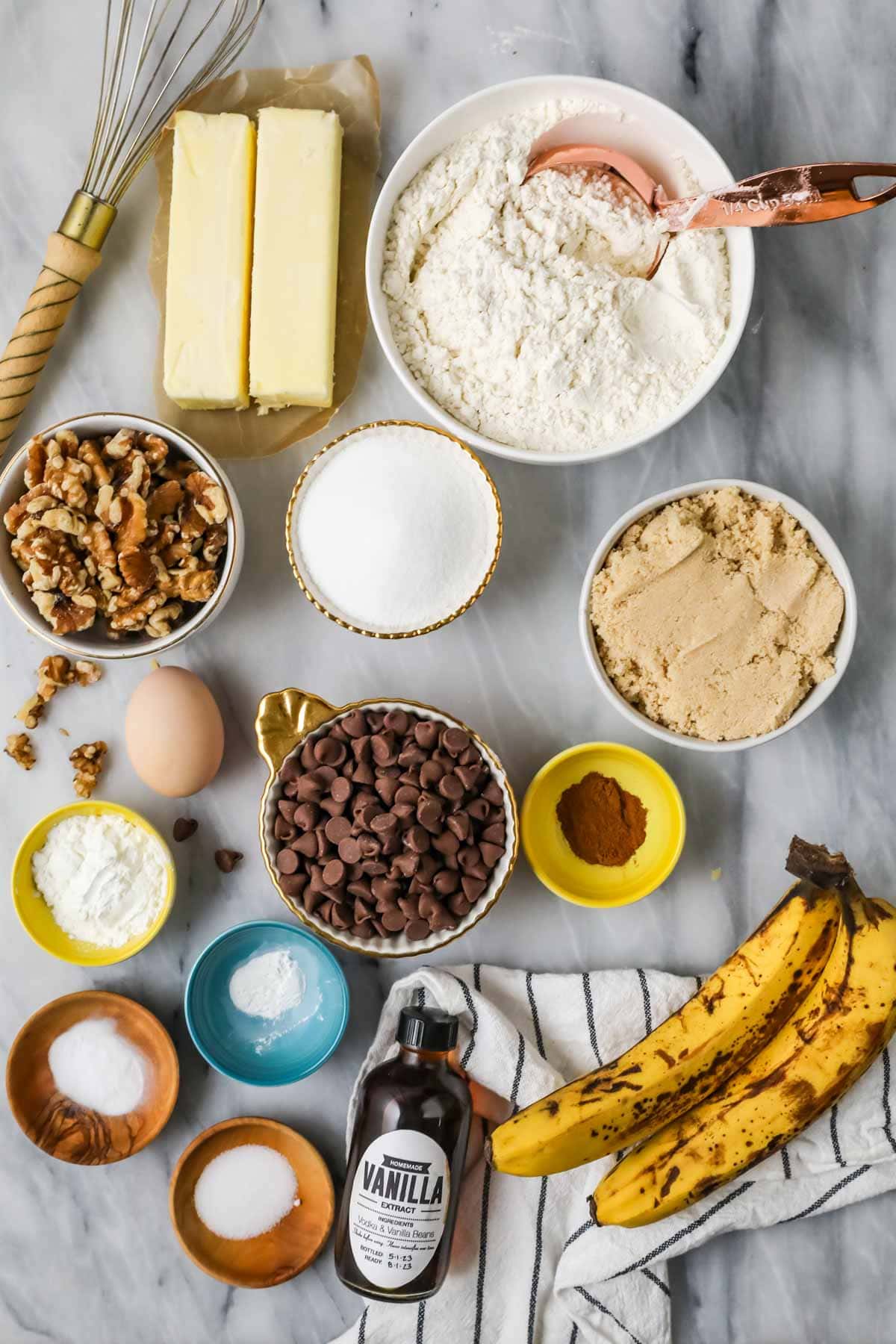 Overhead view of ingredients including bananas, chocolate chips, pecans, and more.