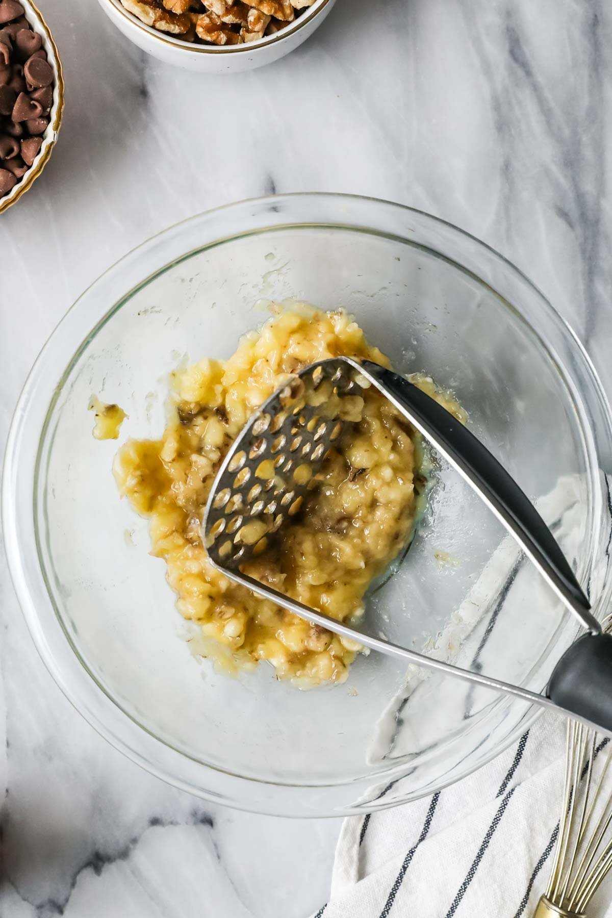 Overhead view of mashed banana in a bowl.