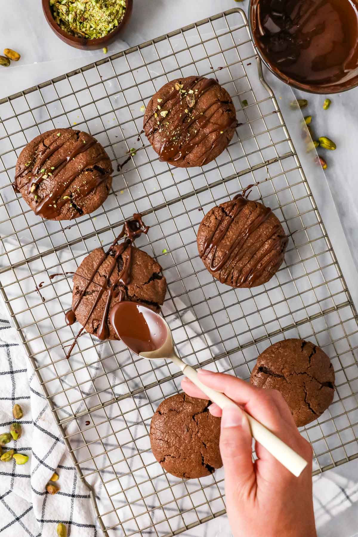 Drizzling melted chocolate over Dubai chocolate cookies.