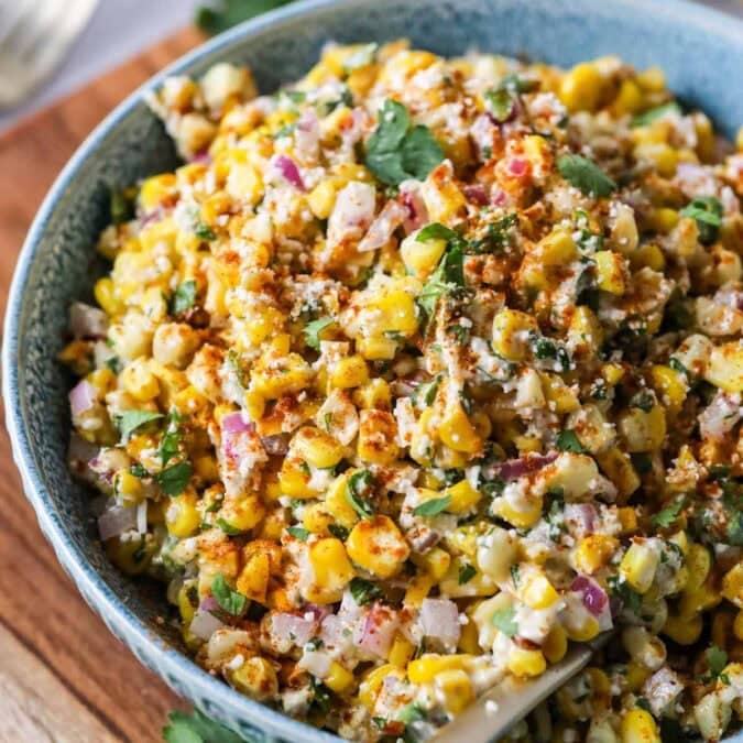 Overhead view of a bowl of Mexican street corn salad in a blue serving bowl.