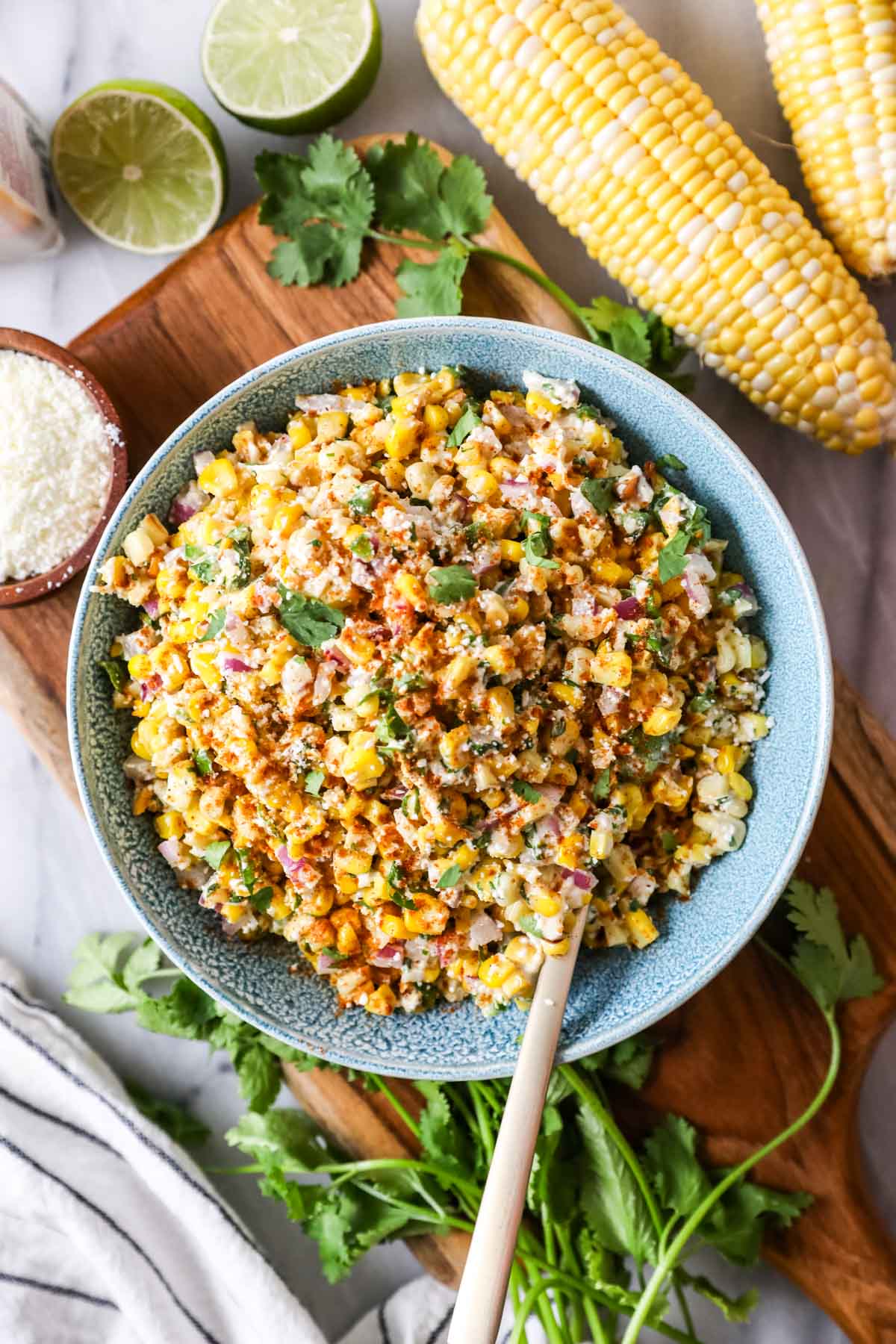 Overhead view of a bowl of Mexican street corn salad in a blue serving bowl.
