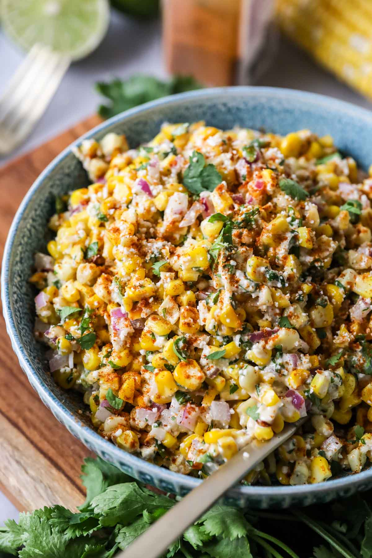 Overhead view of a bowl of Mexican street corn salad in a blue serving bowl. 