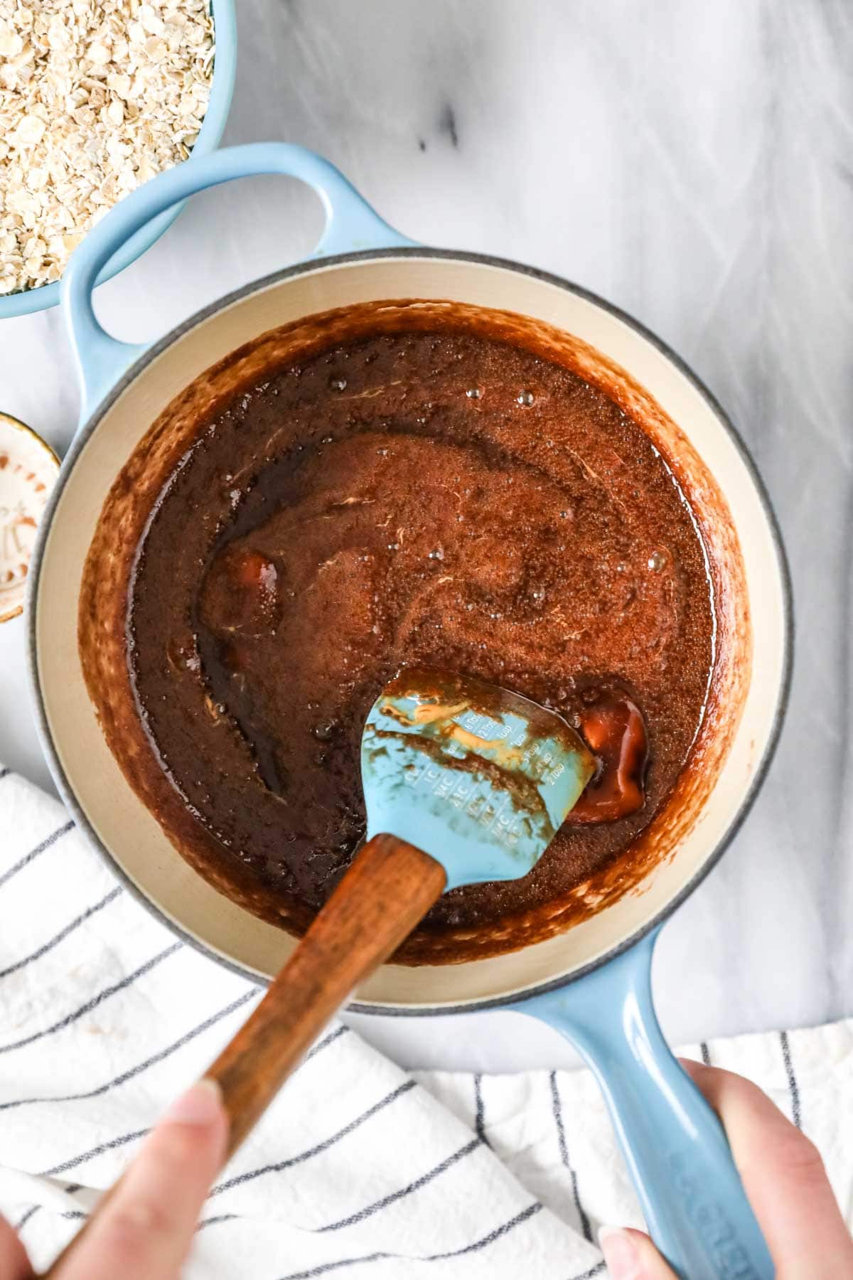 Stirring peanut butter into chocolate mixture for no-bake cookies recipe