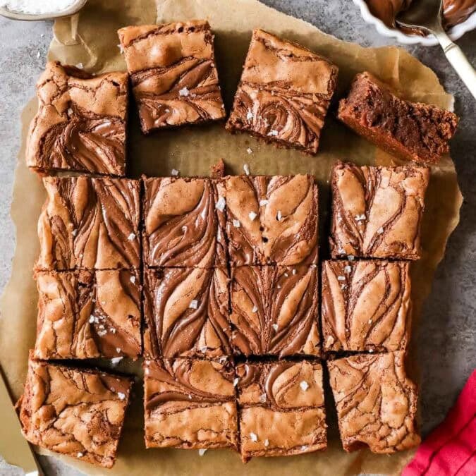 Overhead view of squares of Nutella brownies with swirled tops and sea salt.