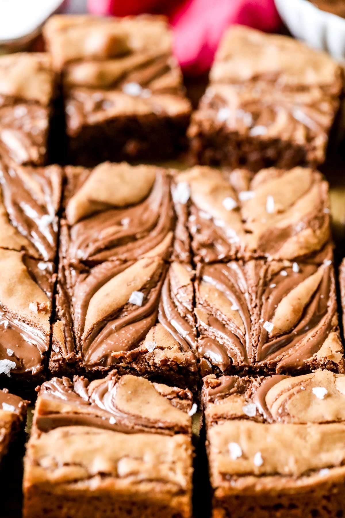 Overhead view of squares of Nutella brownies with swirled tops and sea salt.