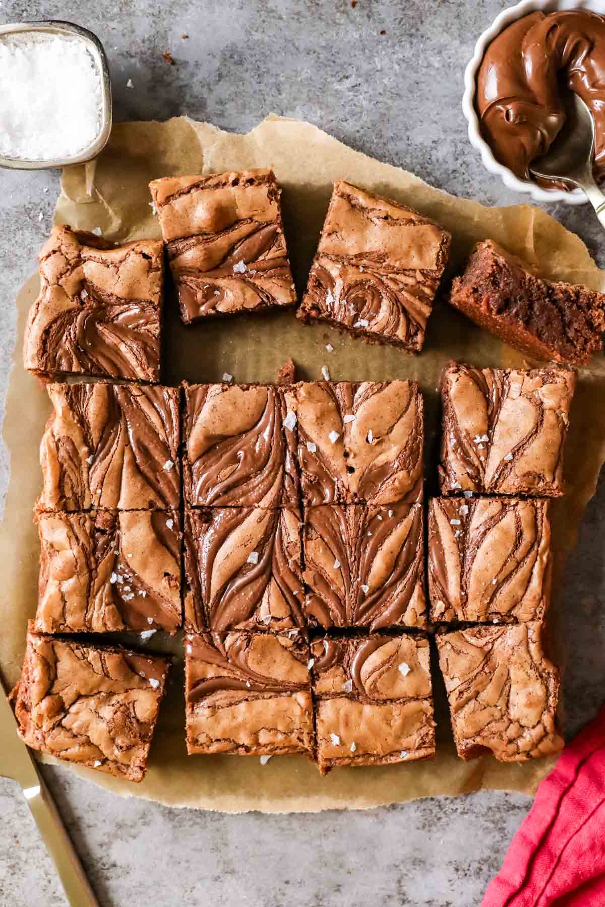 Overhead view of squares of Nutella brownies with swirled tops and sea salt.