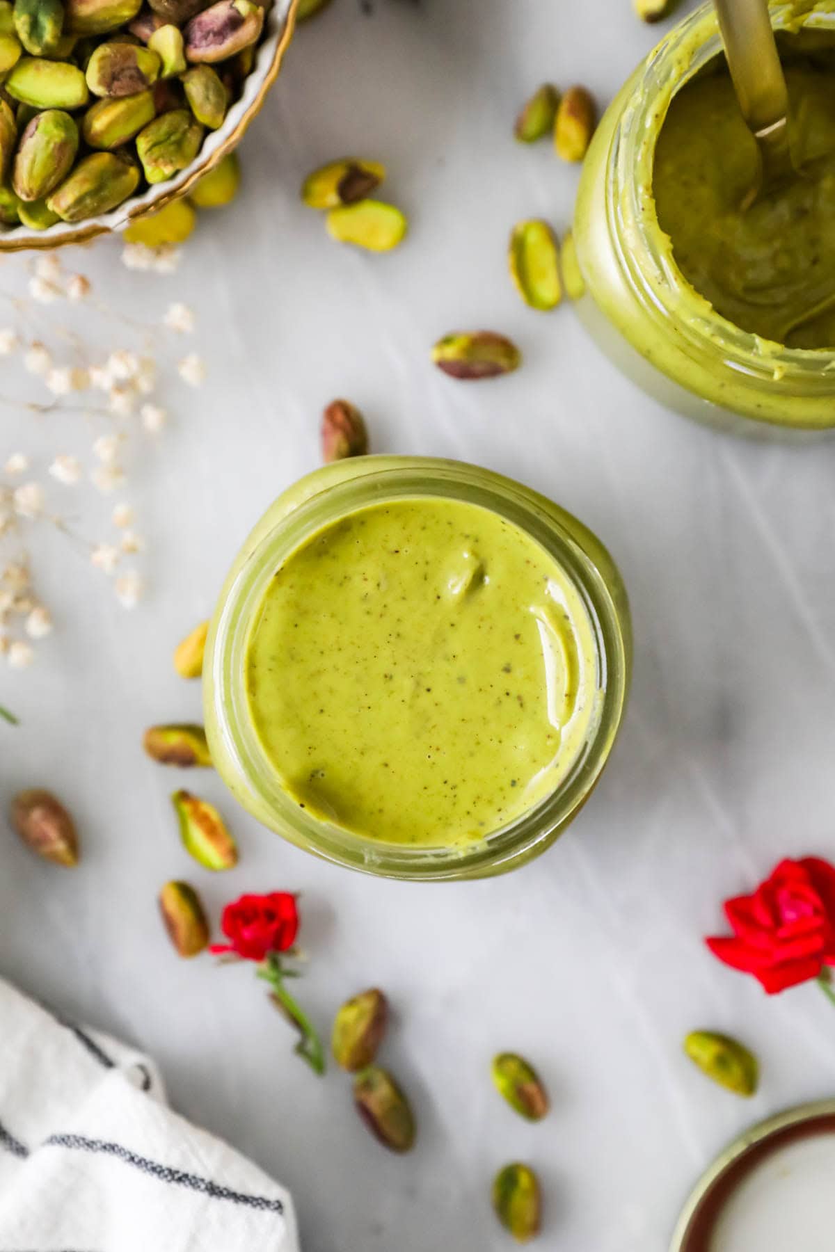 Overhead view of a jar of cream made from pistachios.