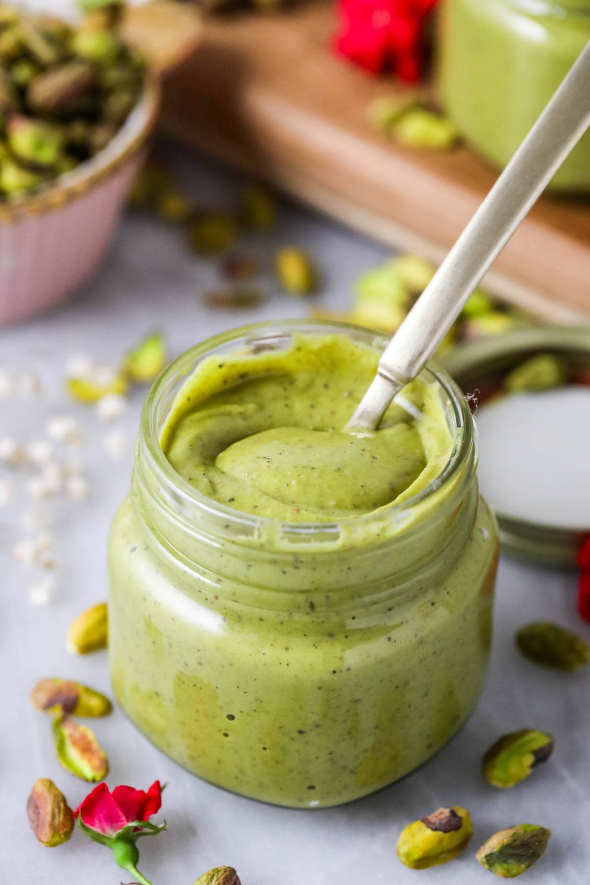Spoon stirring a jar of a homemade pistachio spread.