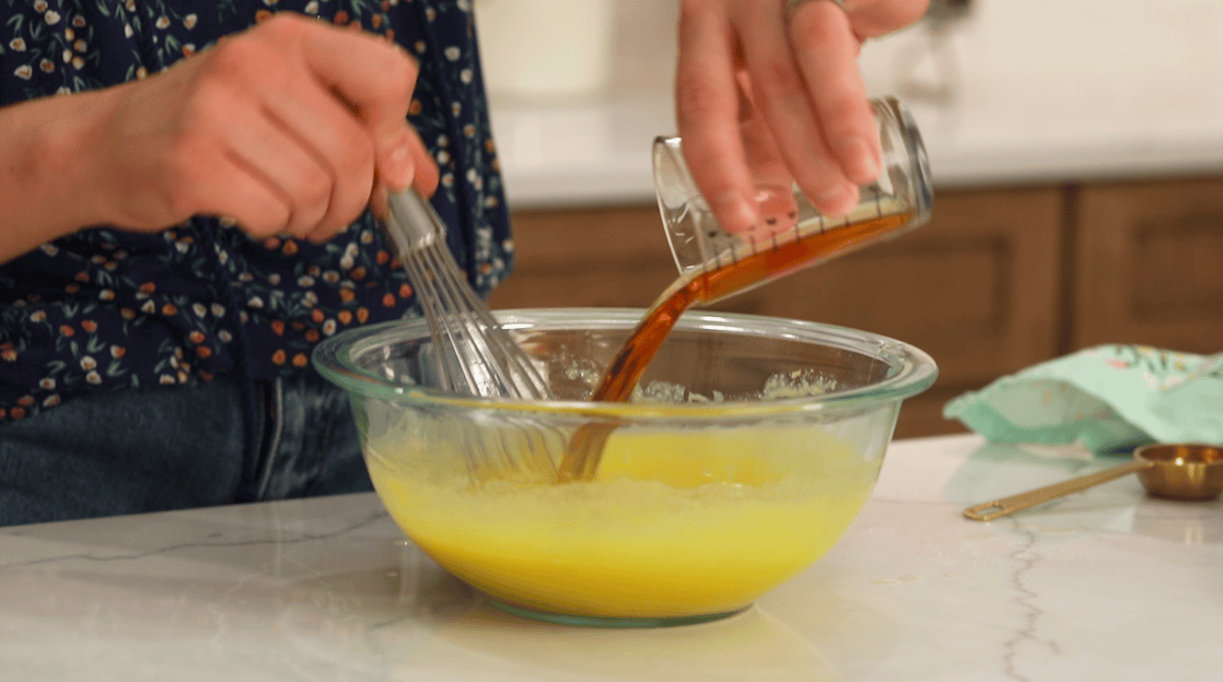 Rum being poured into an egg yolk mixture.