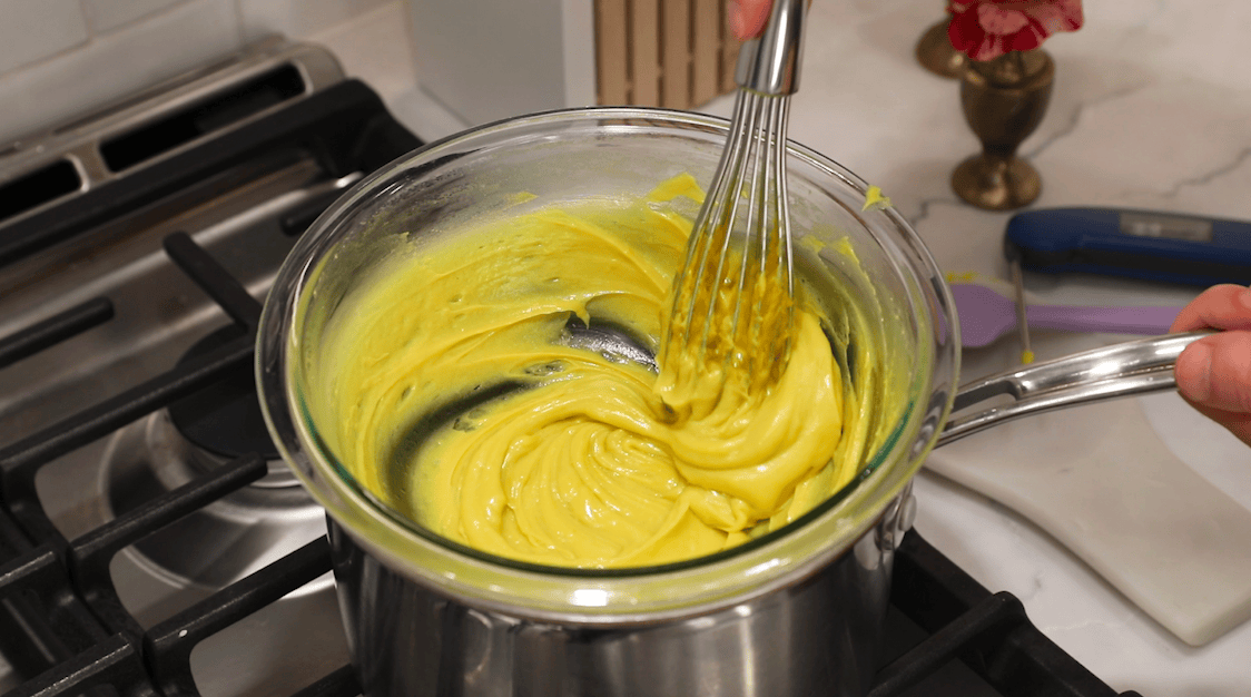 Zabaglione being stirred with a whisk in a double boiler.