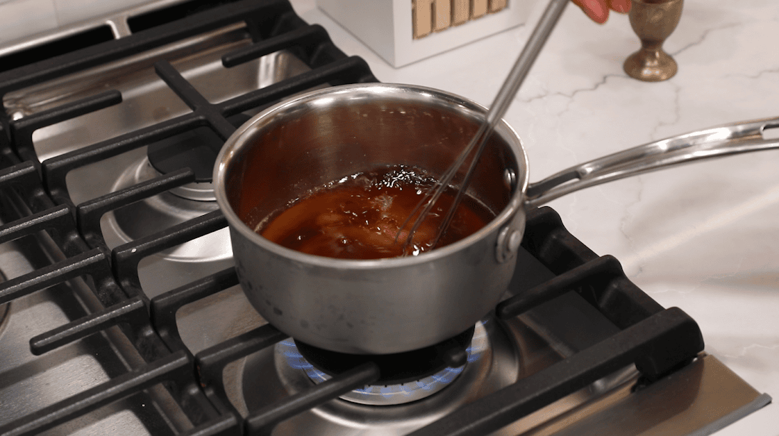 Simple syrup made with coffee, sugar, and rum being prepared on the stovetop.