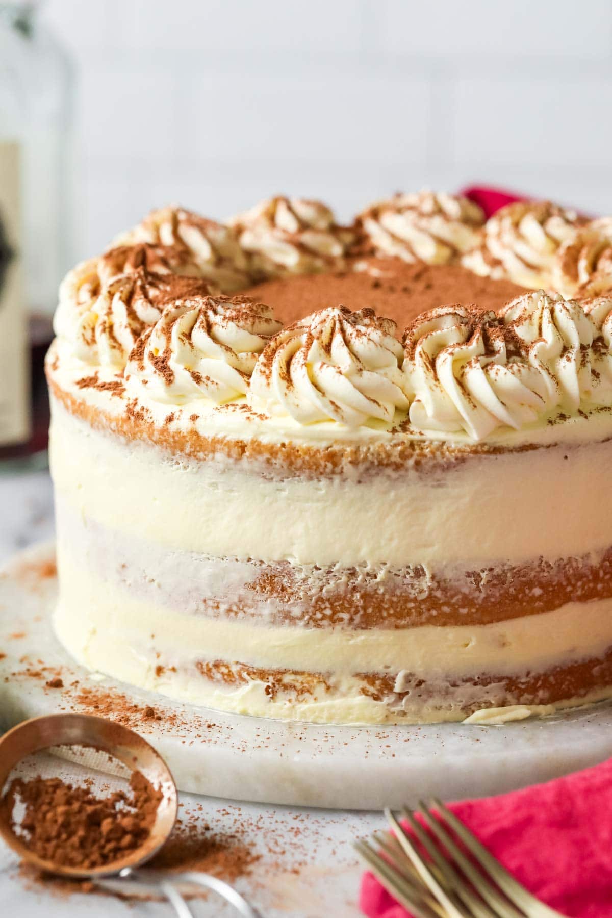 Cake made with three layers of coffee and rum soaked cake with a mascarpone frosting in between and cocoa powder dusted on top.