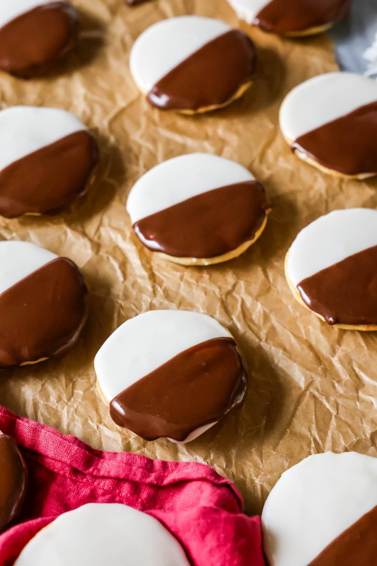 Homemade black and white cookies on brown parchment paper.