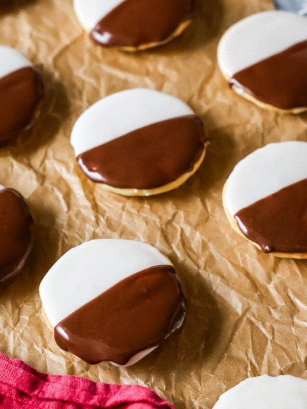Homemade black and white cookies on brown parchment paper.