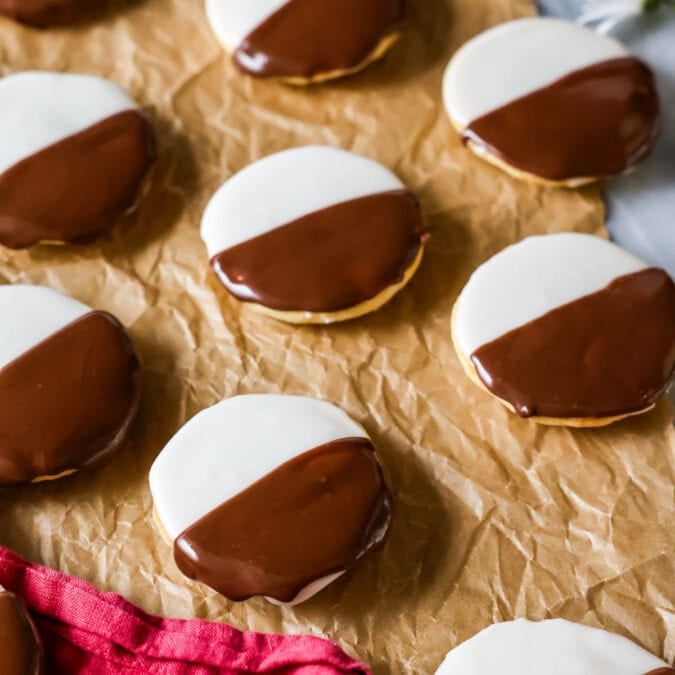 Homemade black and white cookies on brown parchment paper.