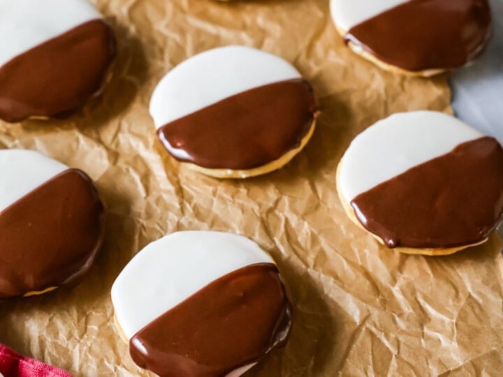 Homemade black and white cookies on brown parchment paper.