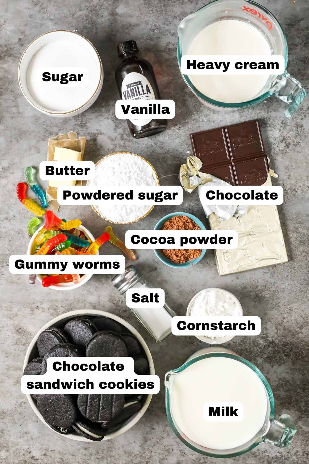 Overhead view of labeled ingredients including gummy worms, Oreos, chocolate, and more.