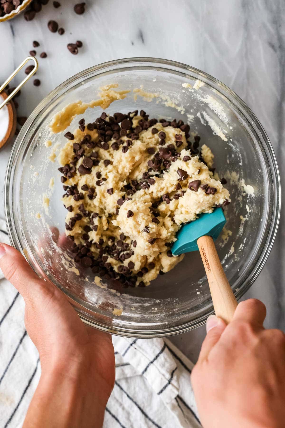 Elevated view of folding chocolate chips into cookie crispy batter.