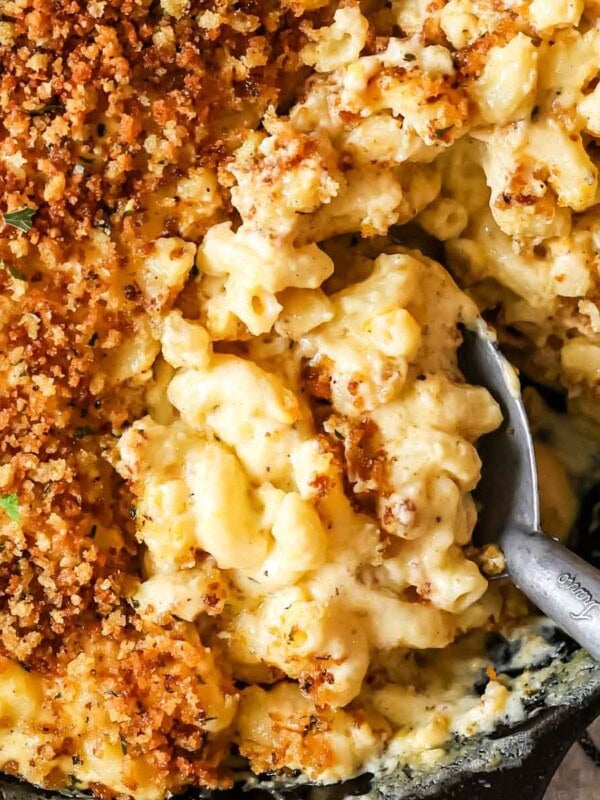 Close-up of creamy, cheesy baked mac and cheese in dish with serving spoon and crispy panko.