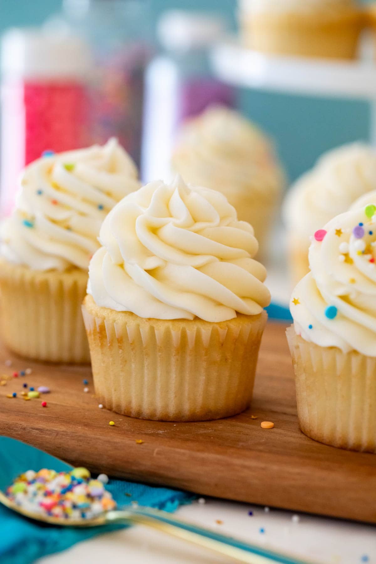 Cupcakes topped with piped American buttercream swirls and sprinkles.