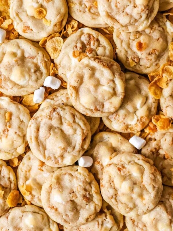 Overhead view of cornflake cookies surrounded by cornflakes and mini marshmallows.