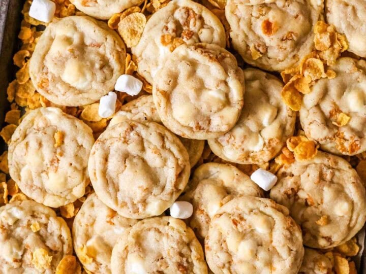 Overhead view of cornflake cookies surrounded by cornflakes and mini marshmallows.