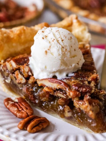 Slice of pecan pie with ice cream on top.