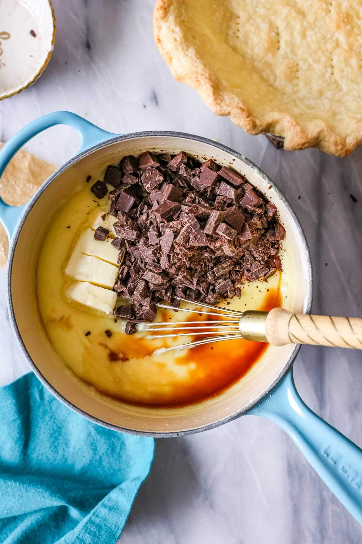 Chopped chocolate, butter, and vanilla added to a custard before whisking in.