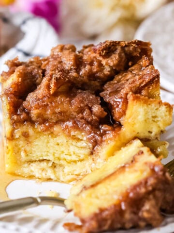 Serving of French toast casserole on a plate with one bite on a fork.