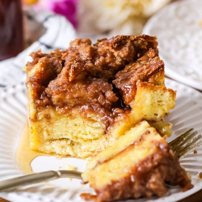 Serving of French toast casserole on a plate with one bite on a fork.