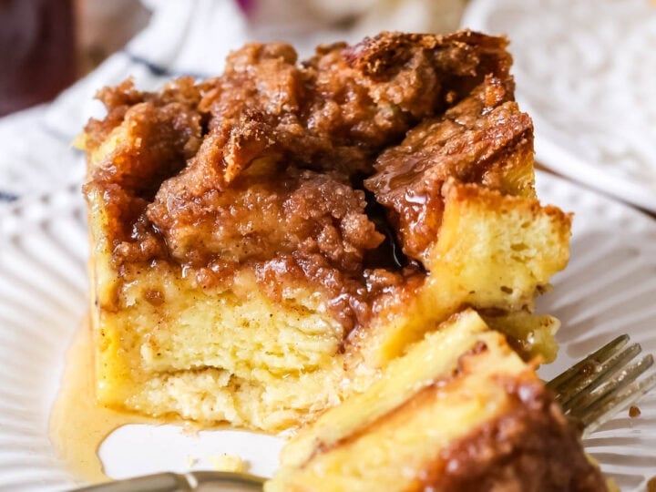 Serving of French toast casserole on a plate with one bite on a fork.