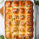 Overhead view of a pan of garlic bread dinner rolls.