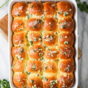 Overhead view of a pan of garlic bread dinner rolls.