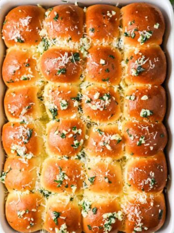Overhead view of a pan of garlic bread dinner rolls.