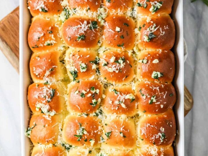 Overhead view of a pan of garlic bread dinner rolls.