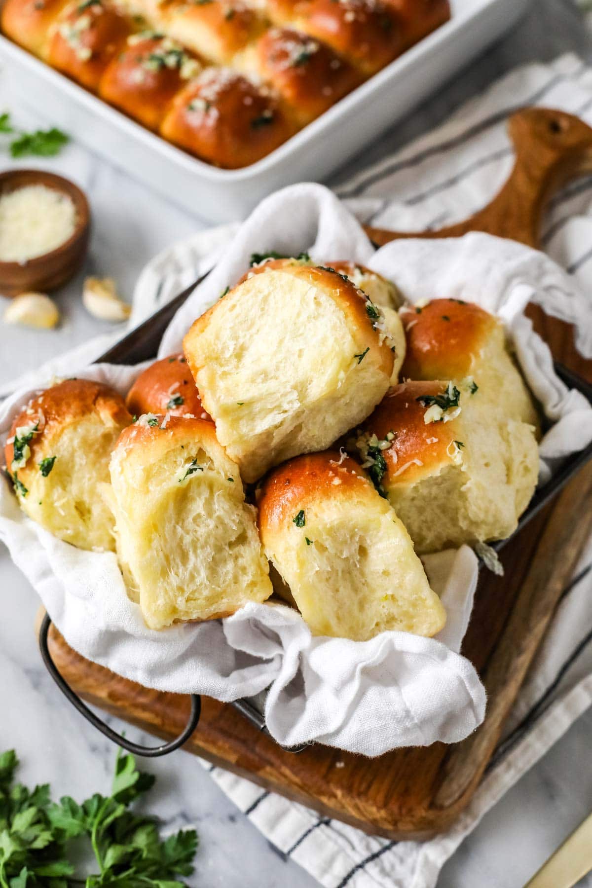Garlic bread dinner rolls in a white towel.