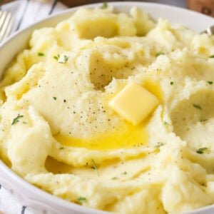 Bowl of mashed potatoes topped with a melting pat of butter.