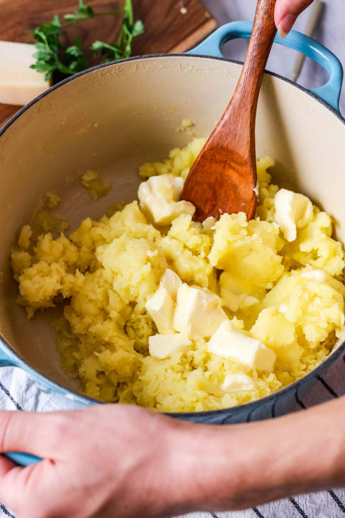 Butter being stirred into potatoes after mashing.