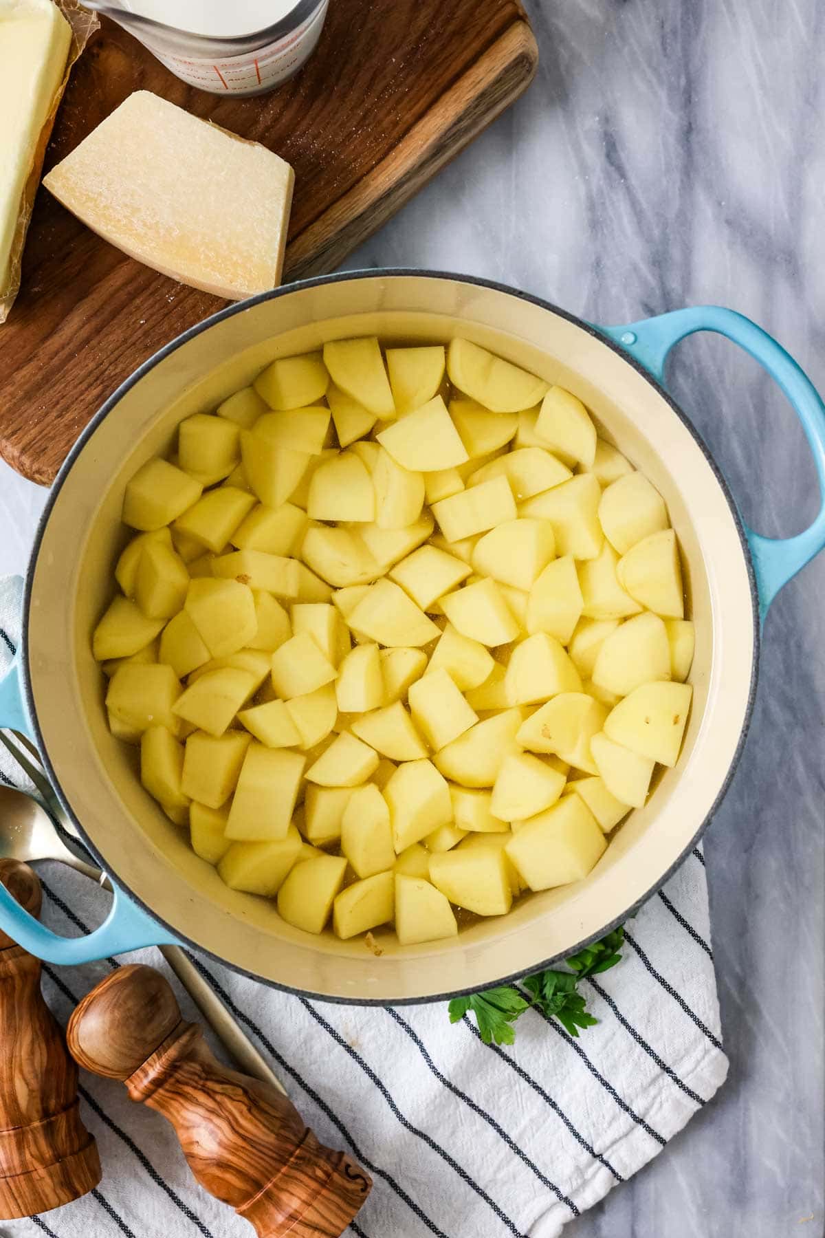 Overhead view of chopped potatoes in a pot.