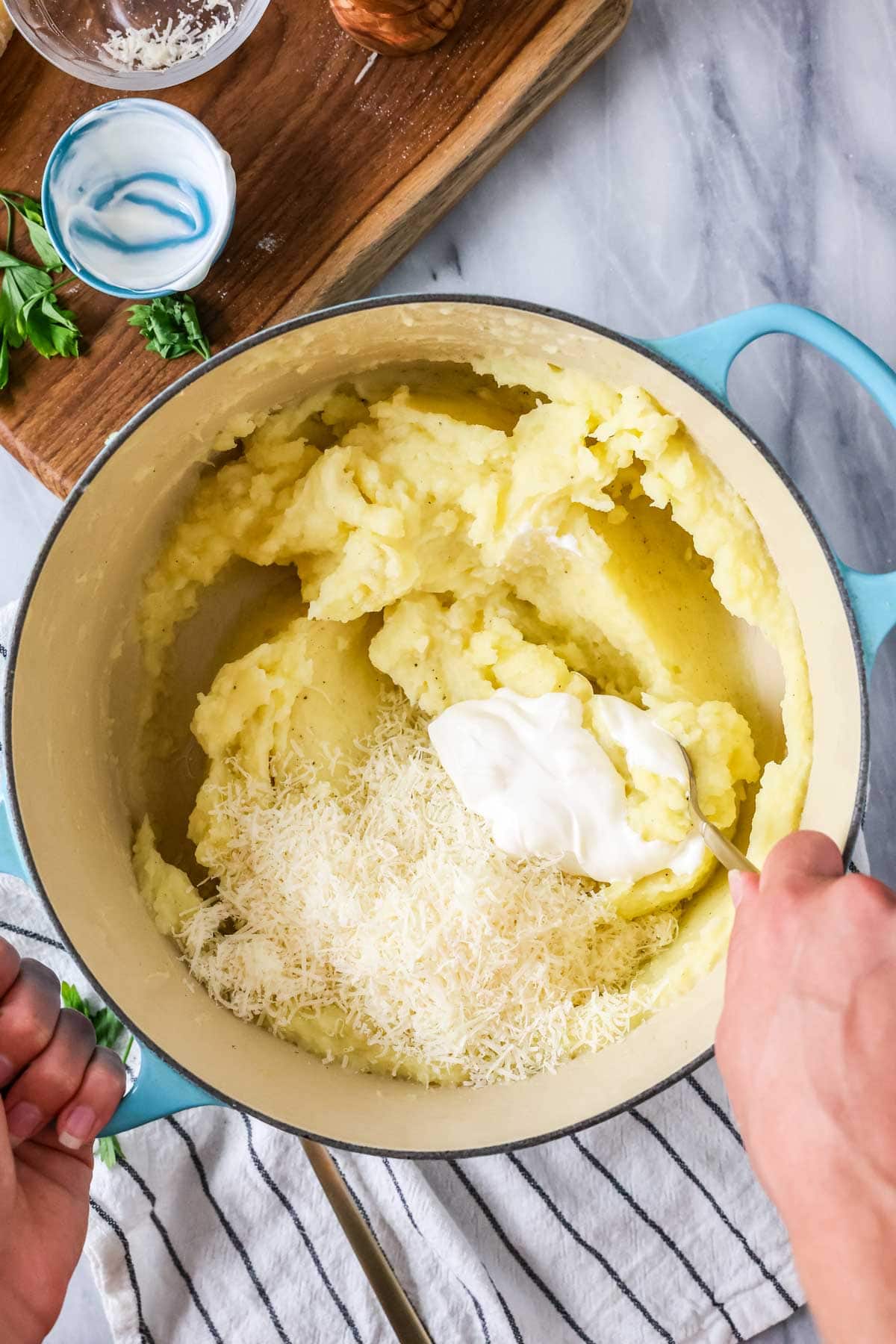 Overhead view of milk being stirred into mashed potatoes.