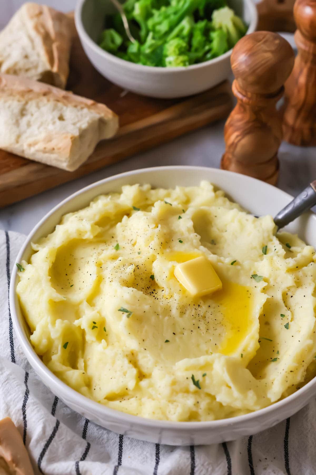 Bowl of mashed potatoes topped with a melting pat of butter.