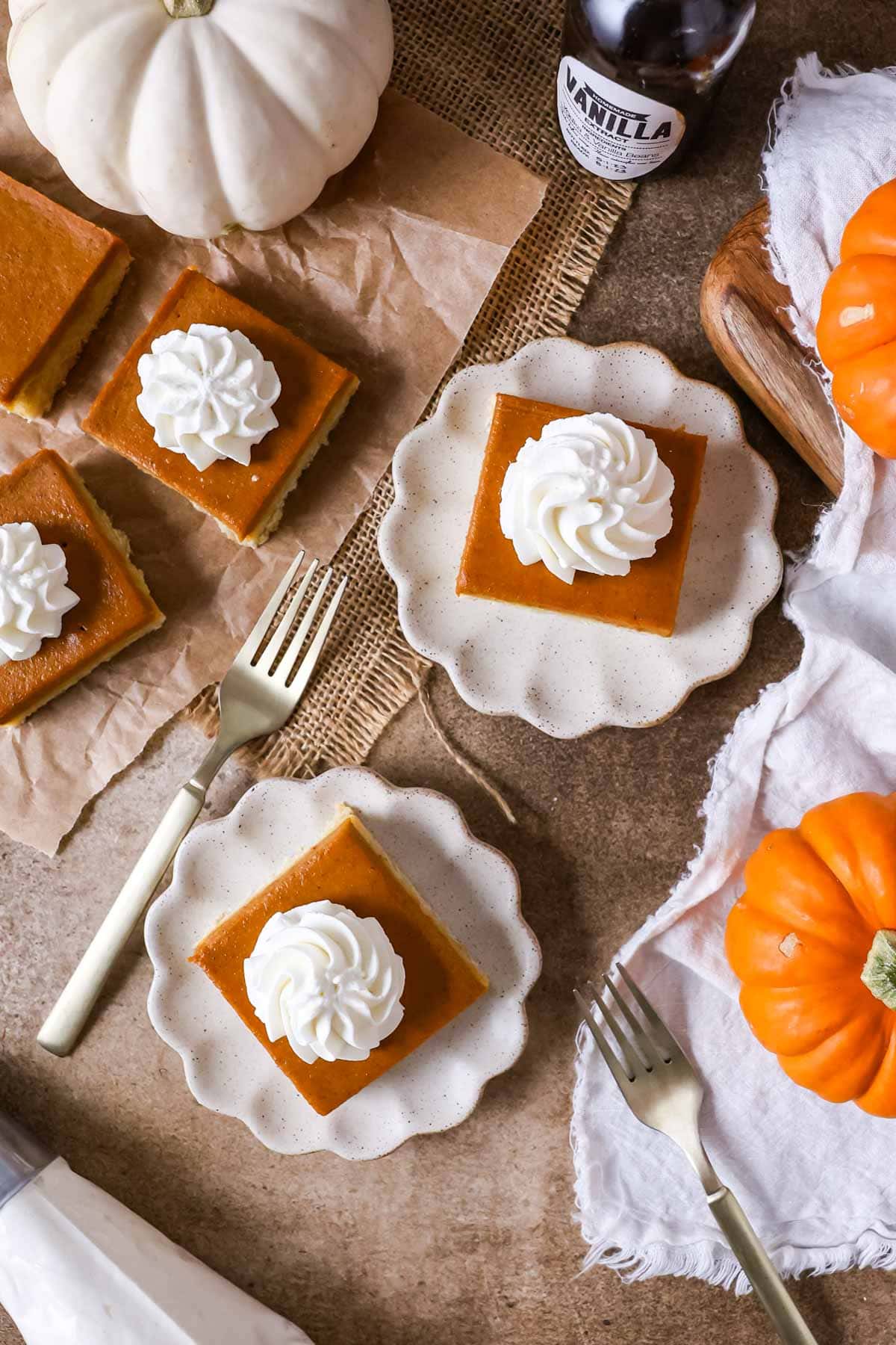 Overhead view of bars made with pumpkin puree topped with whipped cream.