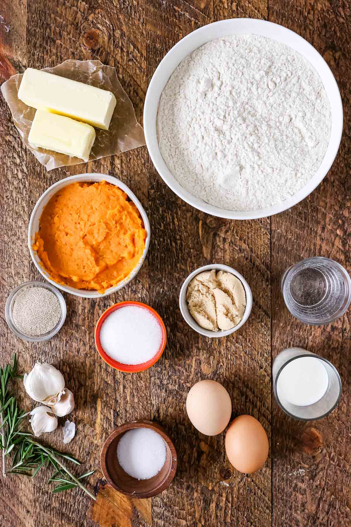 Overhead view of ingredients including mashed sweet potato, yeast, bread flour, and more.