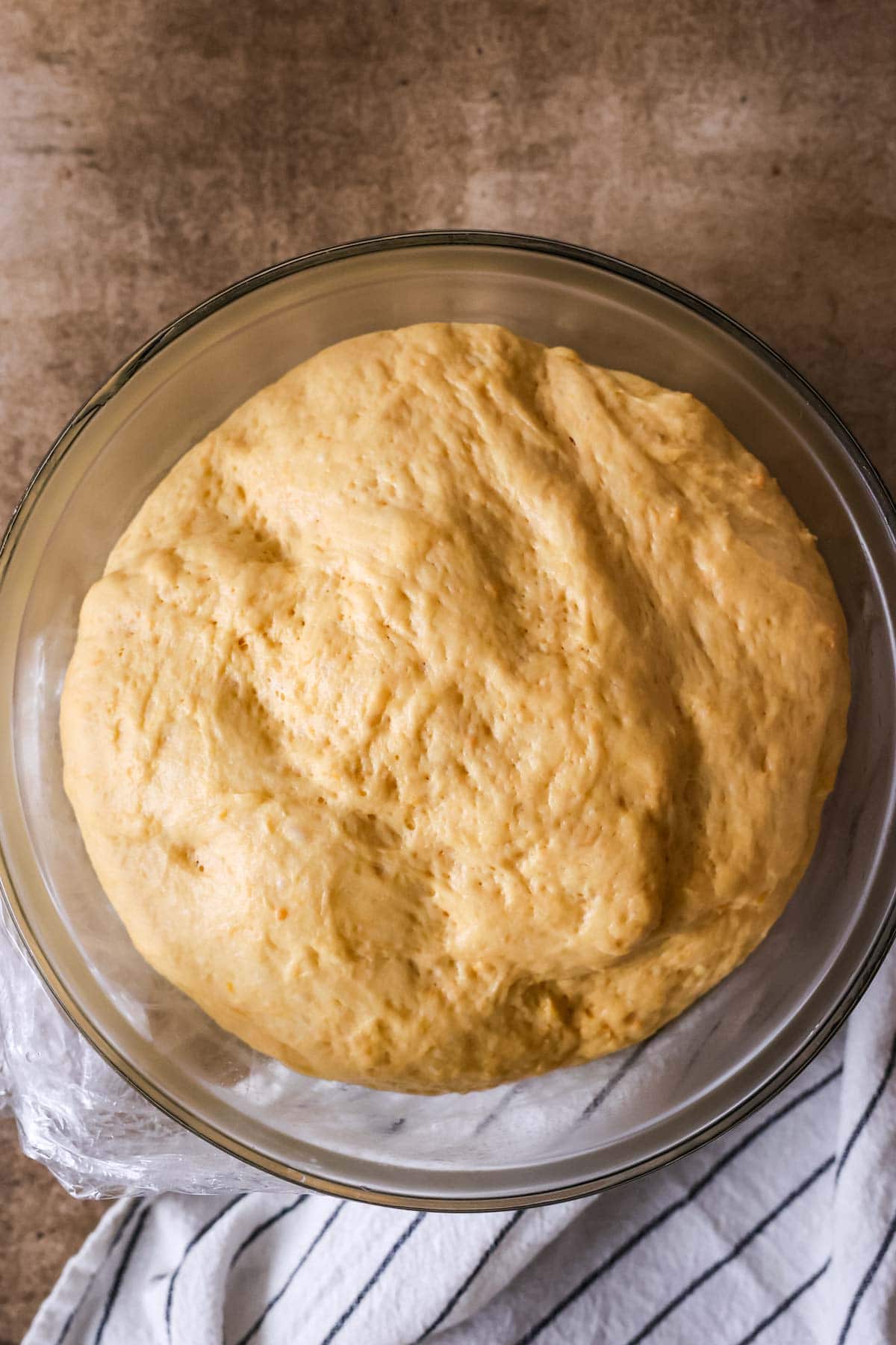 Overhead view of an orange colored dough after rising.