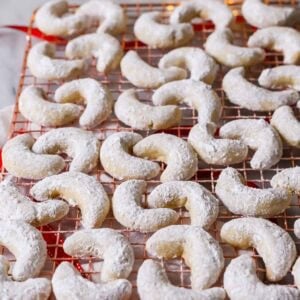 Almond crescent cookies on a cooling rack.