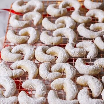 Almond crescent cookies on a cooling rack.
