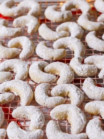 Almond crescent cookies on a cooling rack.