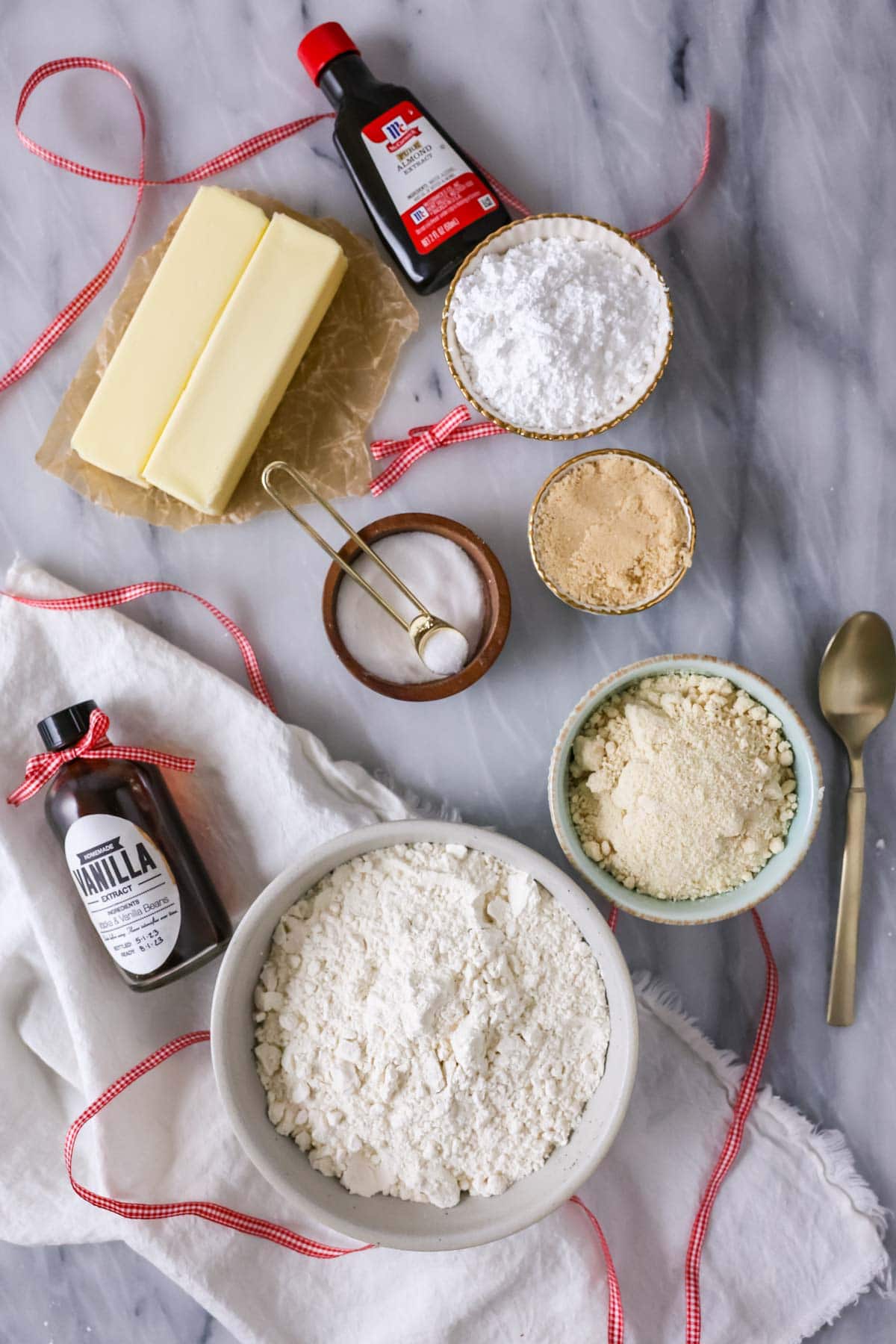 Overhead view of ingredients including almond extract, almond flour, powdered sugar, and more.