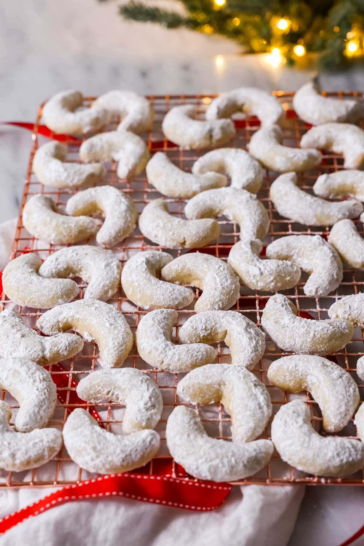 Almond crescent cookies on a cooling rack.